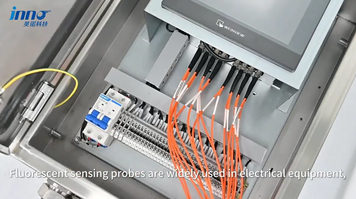 Fluorescent fiber optic temperature probes routed through an electrical monitoring cabinet