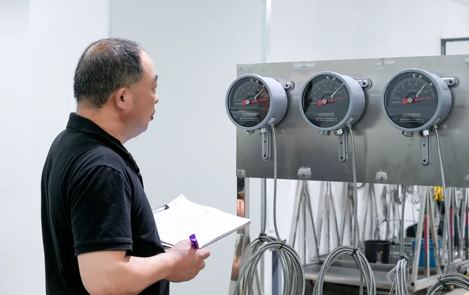 Technician inspecting three transformer temperature gauges with capillary tubes and sensing bulbs